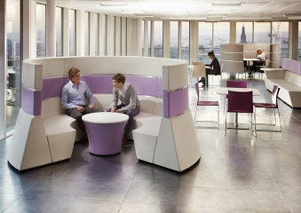 A man and a woman having an informal meeting in a office pod 