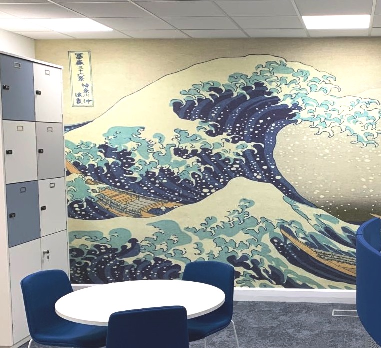 Wave design feature wall in a room with lockers and a circular table 